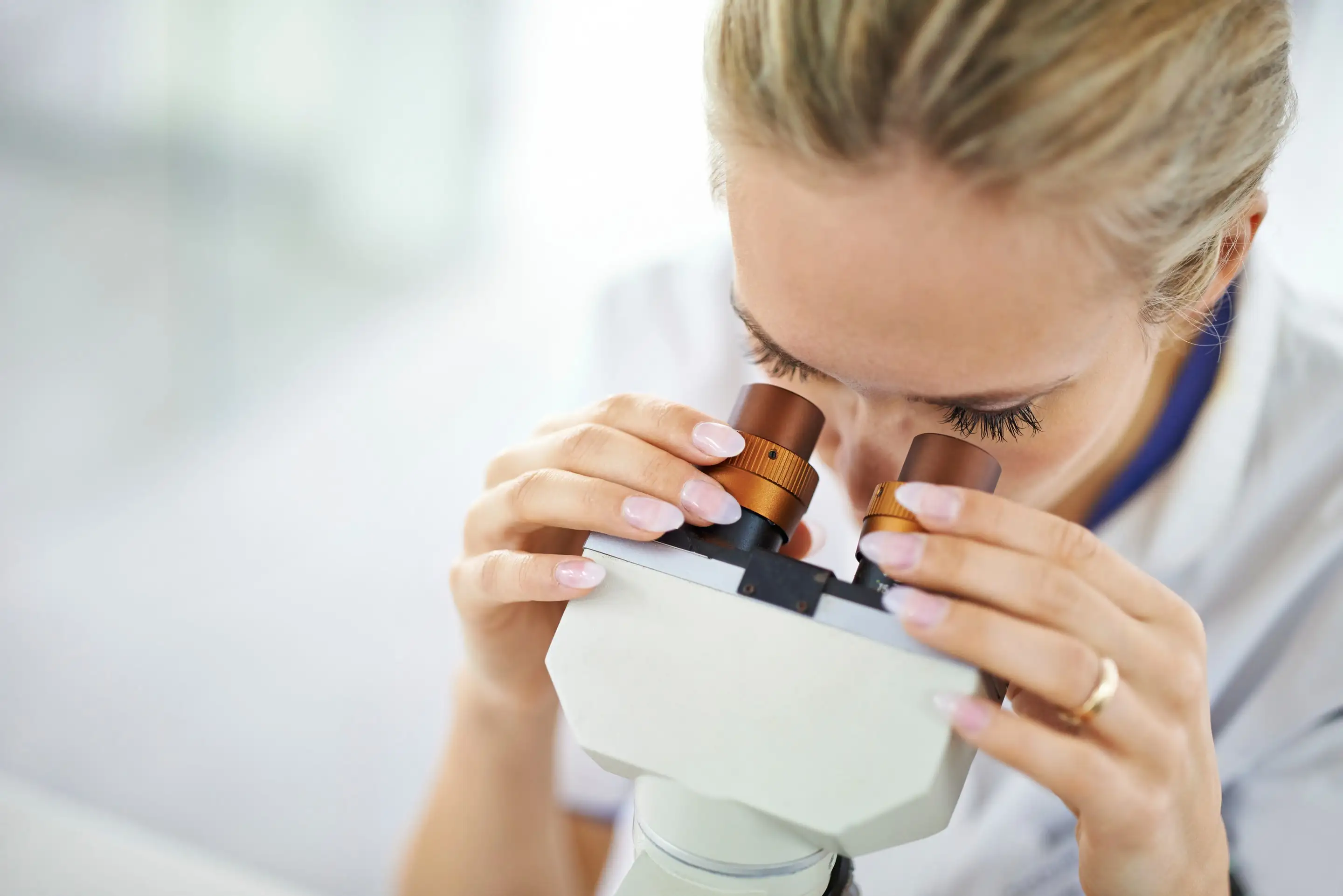 Researcher examining a sample through a microscope