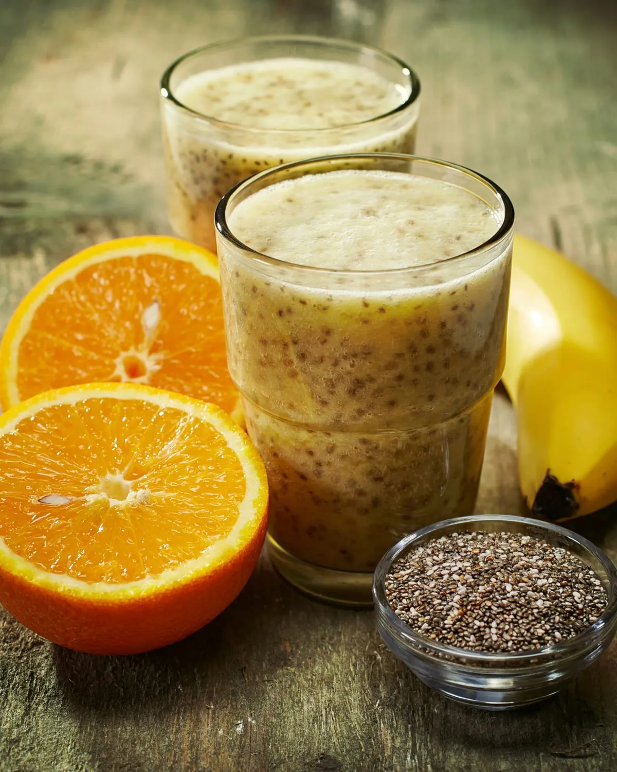 Glasses of drinkable yoghurt with chia, orange and banana